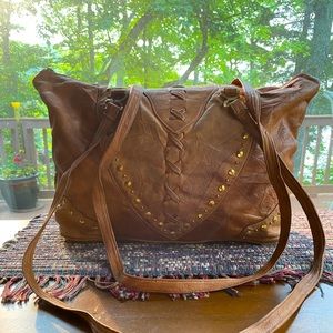 Soft leather lined east west tote. 18”W x 11”H x 5”D. Antique brass metal trim.